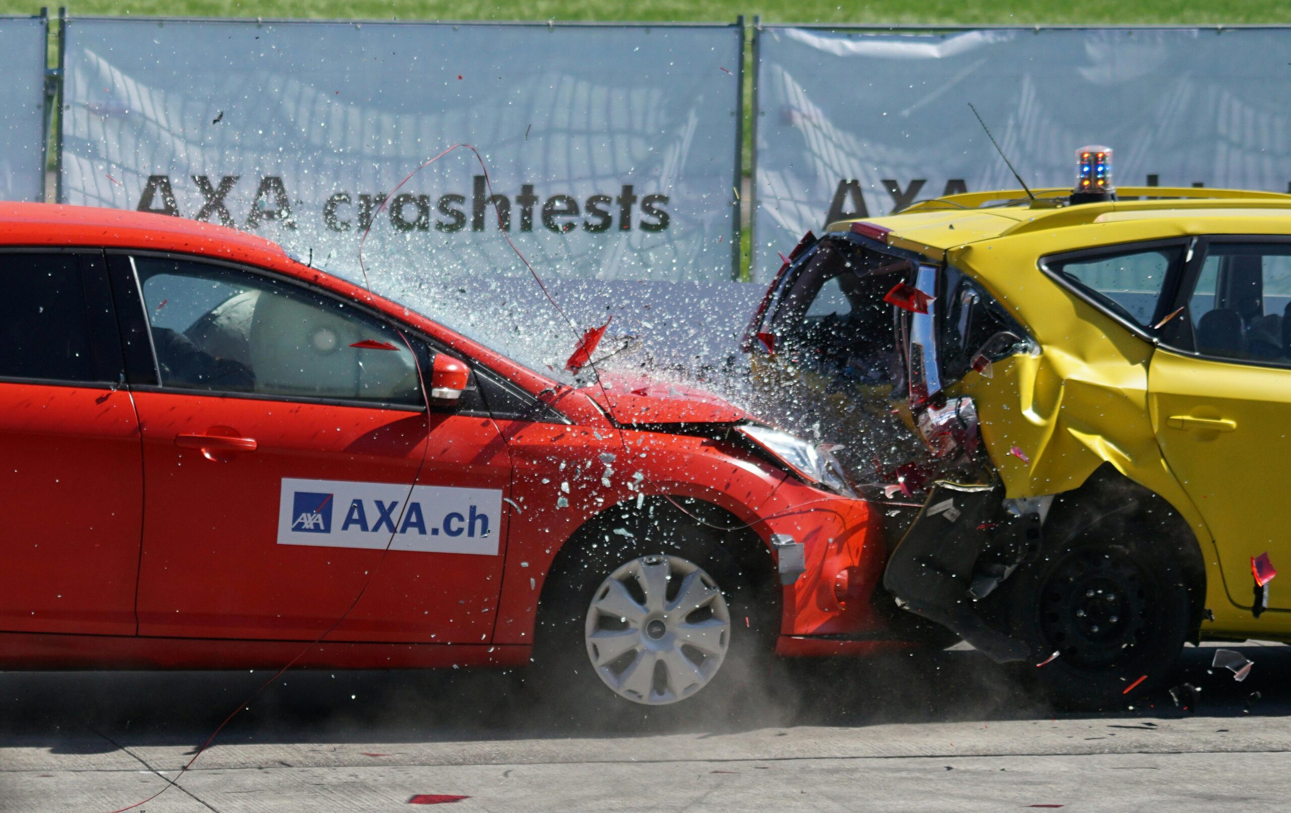Home Red and yellow cars shown in a head-on collision during a crash test for safety evaluation.
